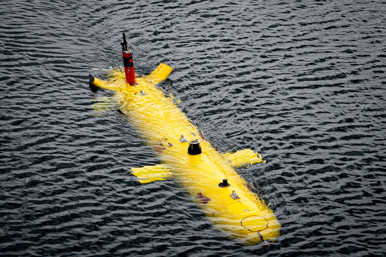 A bright yellow torpedo-shaped autonomous underwater vehicle