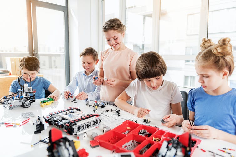 Boys and girls play with lego.