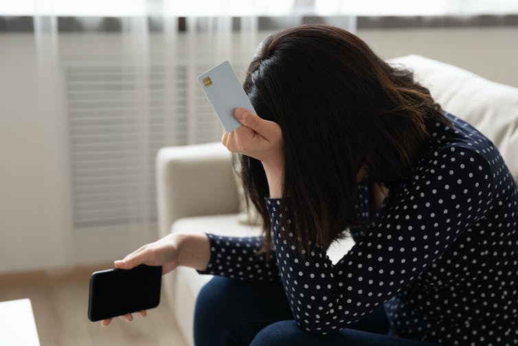 A woman contemplates credit card debt.