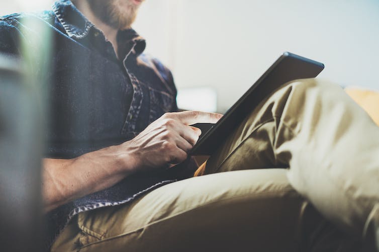 A man browses on an iPad.