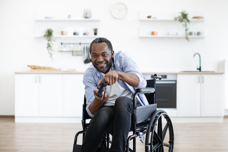a man in a wheelchair with a game controller