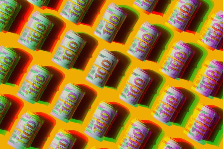A pattern of repeated American dollars, rolled up.